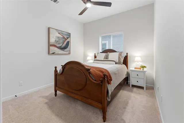 a spacious bedroom with a bed and a chandelier