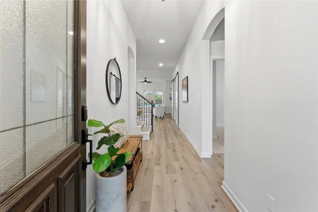 a hallway with painting and a potted plant