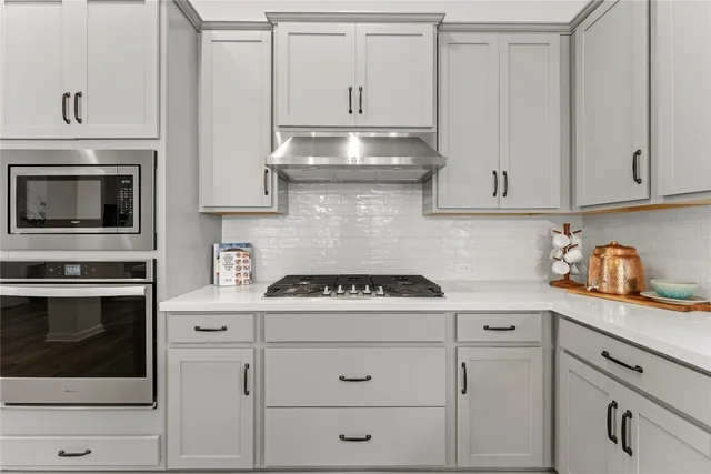a kitchen with granite countertop white cabinets and white appliances