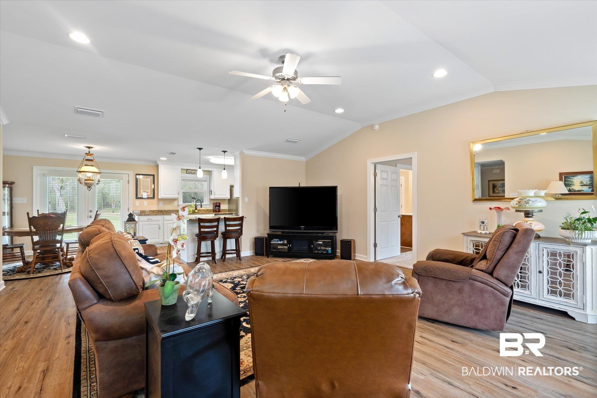 734 West Section Avenue Foley, AL 36535 - Photo 9 of 50 Living room featuring lofted ceiling, crown molding, light wood-style floors, and visible vents