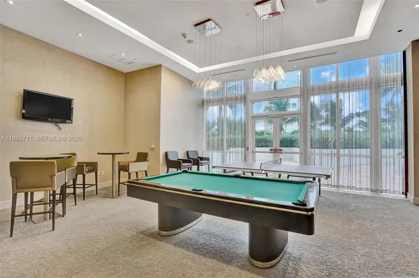 a room with pool table and windows