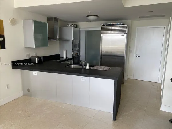 a kitchen with granite countertop a refrigerator and a sink