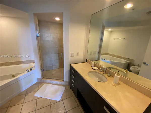 a bathroom with a tub sink and mirror