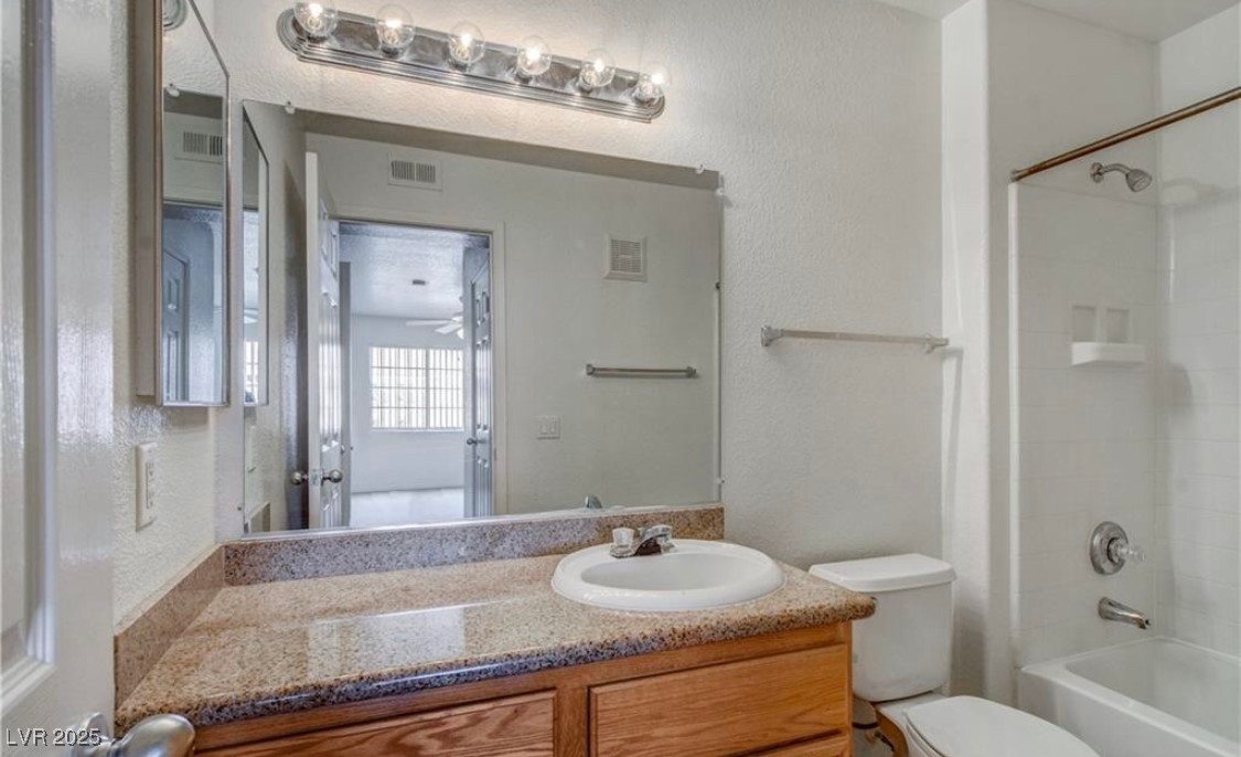3318 North Decatur Boulevard, Unit 2103 Las Vegas, NV 89130 - Photo 12 of 20 Bathroom with vanity, shower / bath combination, and a textured wall