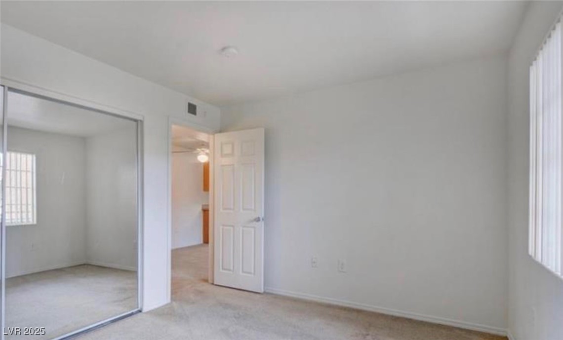 3318 North Decatur Boulevard, Unit 2103 Las Vegas, NV 89130 - Photo 14 of 20 Unfurnished bedroom with light carpet, multiple windows, and a closet