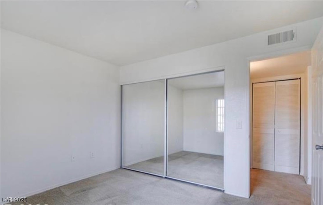 3318 North Decatur Boulevard, Unit 2103 Las Vegas, NV 89130 - Photo 15 of 20 Unfurnished bedroom with carpet floors and a closet
