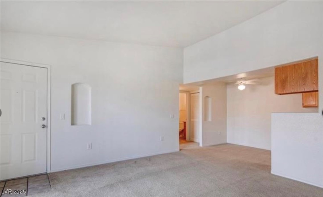 3318 North Decatur Boulevard, Unit 2103 Las Vegas, NV 89130 - Photo 6 of 20 Unfurnished living room featuring carpet and a ceiling fan