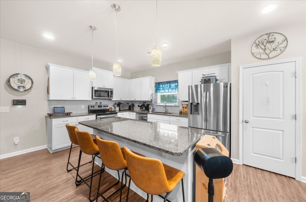 15 Gala Drive Northeast Rome, GA 30165 - Photo 20 of 60 a kitchen with stainless steel appliances granite countertop a table chairs in it and wooden floors