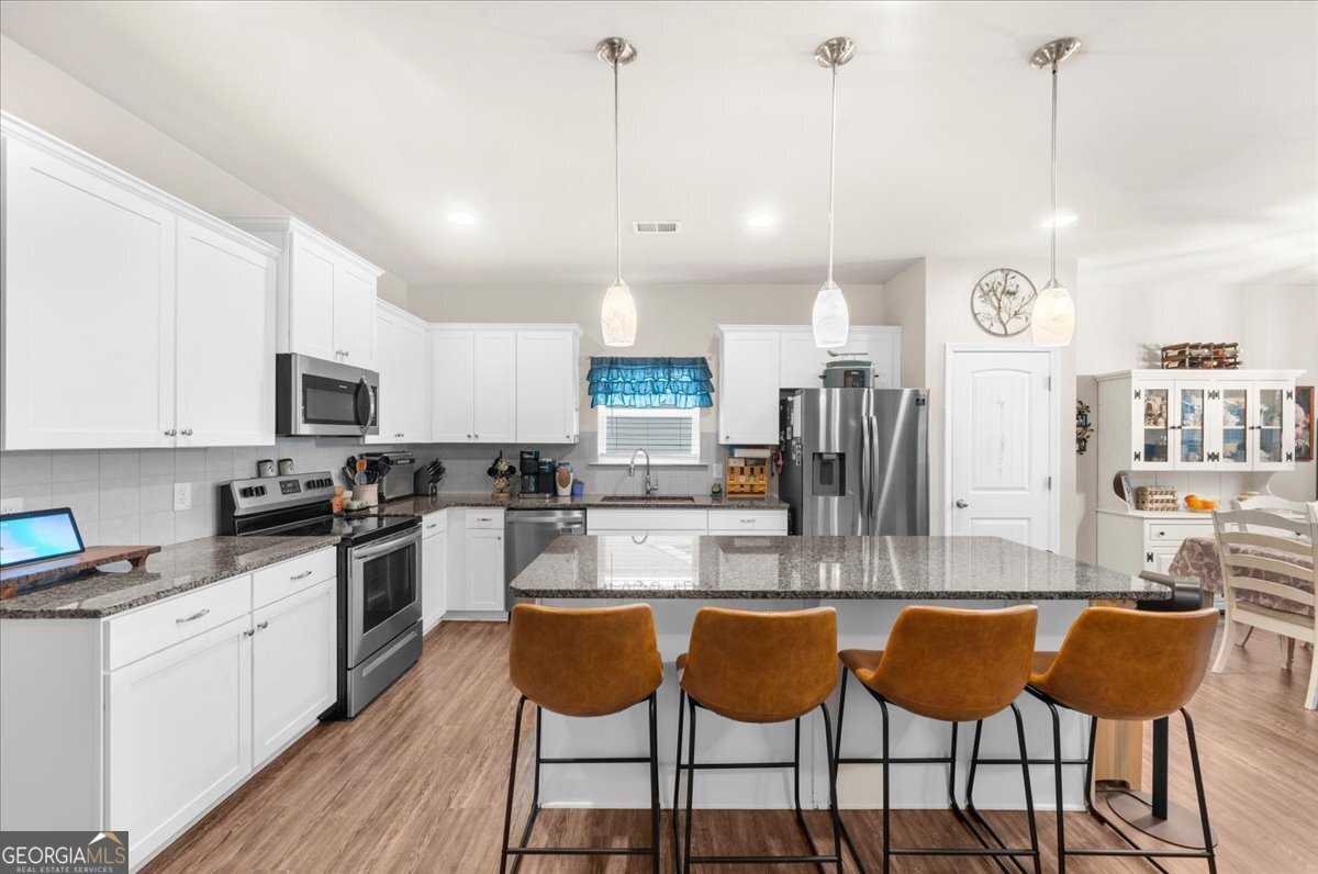 15 Gala Drive Northeast Rome, GA 30165 - Photo 21 of 60 a kitchen with stainless steel appliances kitchen island granite countertop a stove a sink and a refrigerator