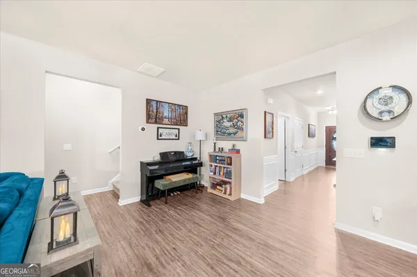 a living room with furniture kitchen view and a large window