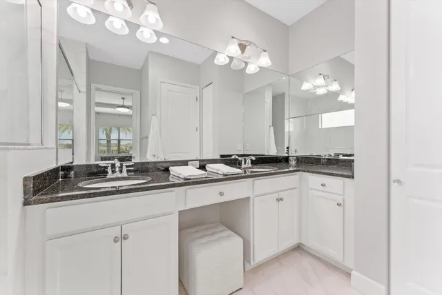 a bathroom with a granite countertop sink a mirror and a shower