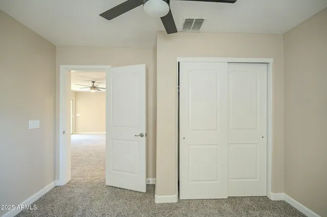 an empty room and chandelier fan