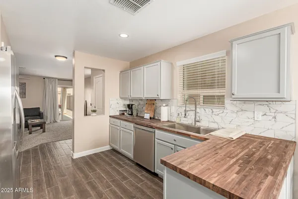 a kitchen with granite countertop a sink stove and cabinets