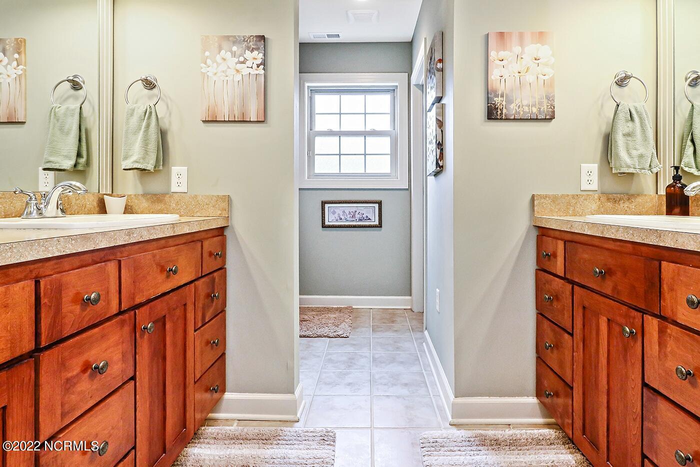 1079 Tulls Creek Road Moyock, NC 27958 - Photo 33 of 59 Full Bath in First Floor Owner’s Suite offers Double Vanities and step in shower with tile surround.