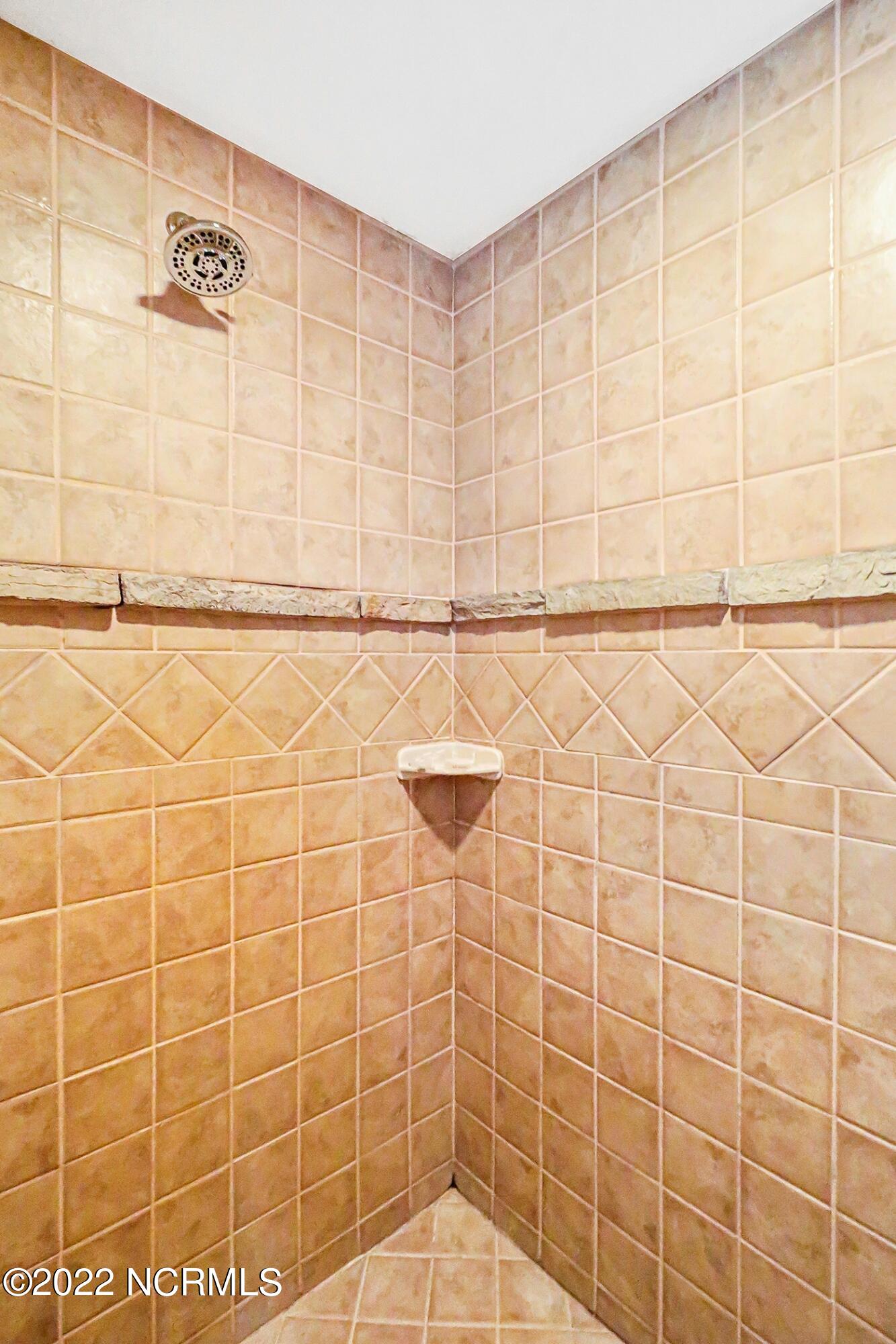 1079 Tulls Creek Road Moyock, NC 27958 - Photo 34 of 59 Full Bath in First Floor Owner’s Suite offers Double Vanities and step in shower with tile surround.