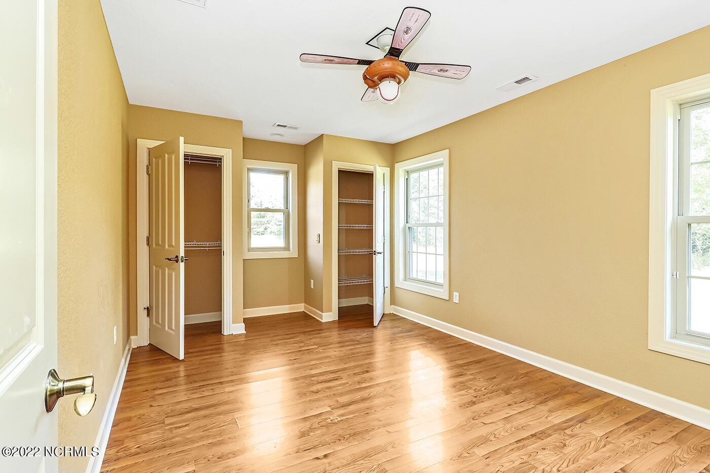 1079 Tulls Creek Road Moyock, NC 27958 - Photo 38 of 59 Secondary Bedroom with overhead lighting, laminate wood flooring and double closets. The secondary bedrooms share a full bathroom on the first floor.