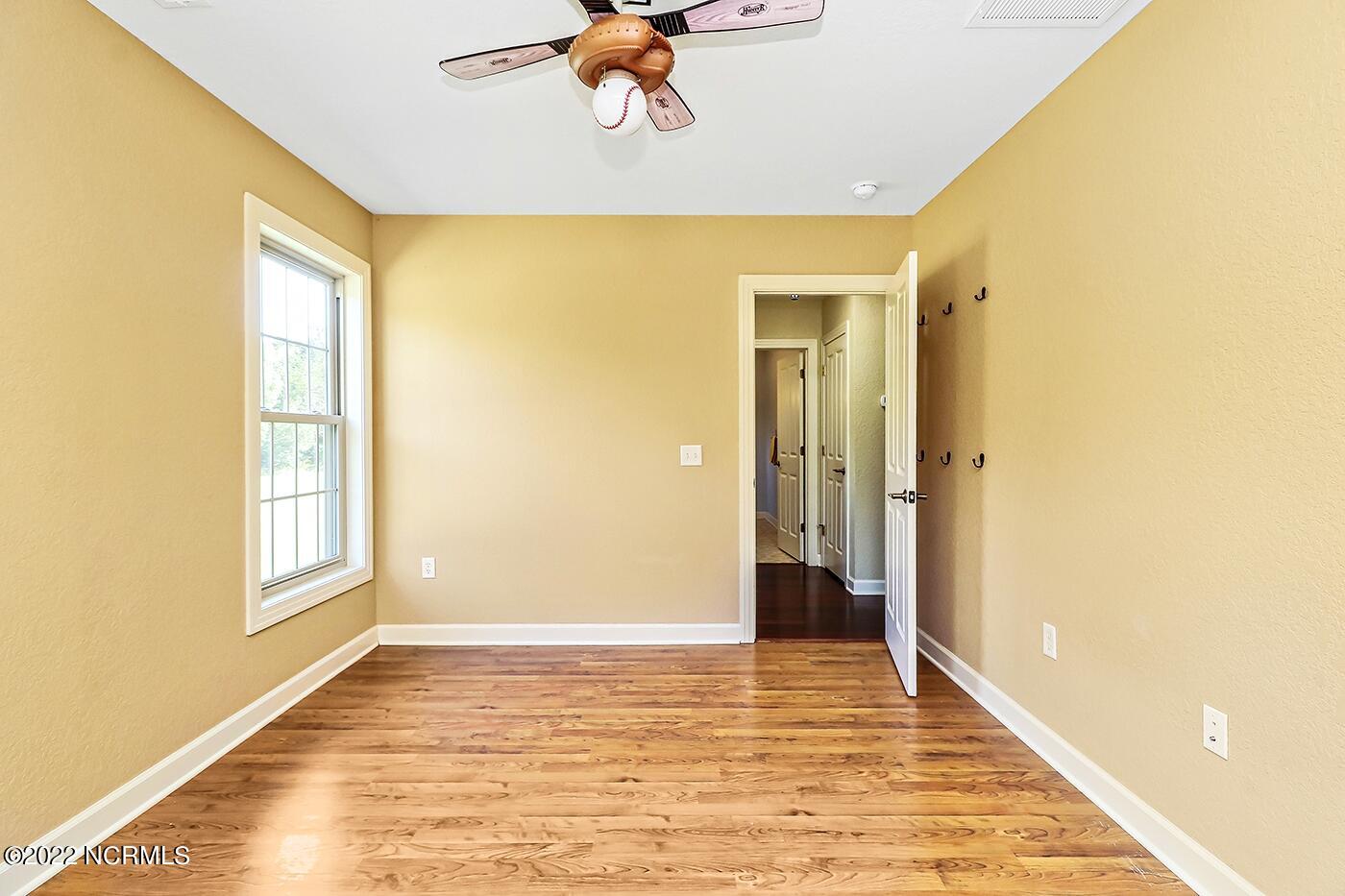 1079 Tulls Creek Road Moyock, NC 27958 - Photo 39 of 59 Secondary Bedroom with overhead lighting, laminate wood flooring and double closets. The secondary bedrooms share a full bathroom on the first floor.