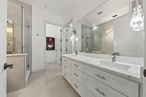 a spacious bathroom with a granite countertop sink mirror and shower