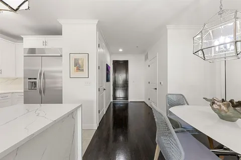 a kitchen with stainless steel appliances a refrigerator a sink a stove and white cabinets