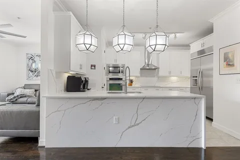 a kitchen with stainless steel appliances granite countertop a sink a stove and a wooden floors