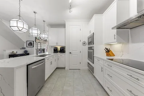a kitchen with stainless steel appliances granite countertop a sink and cabinets