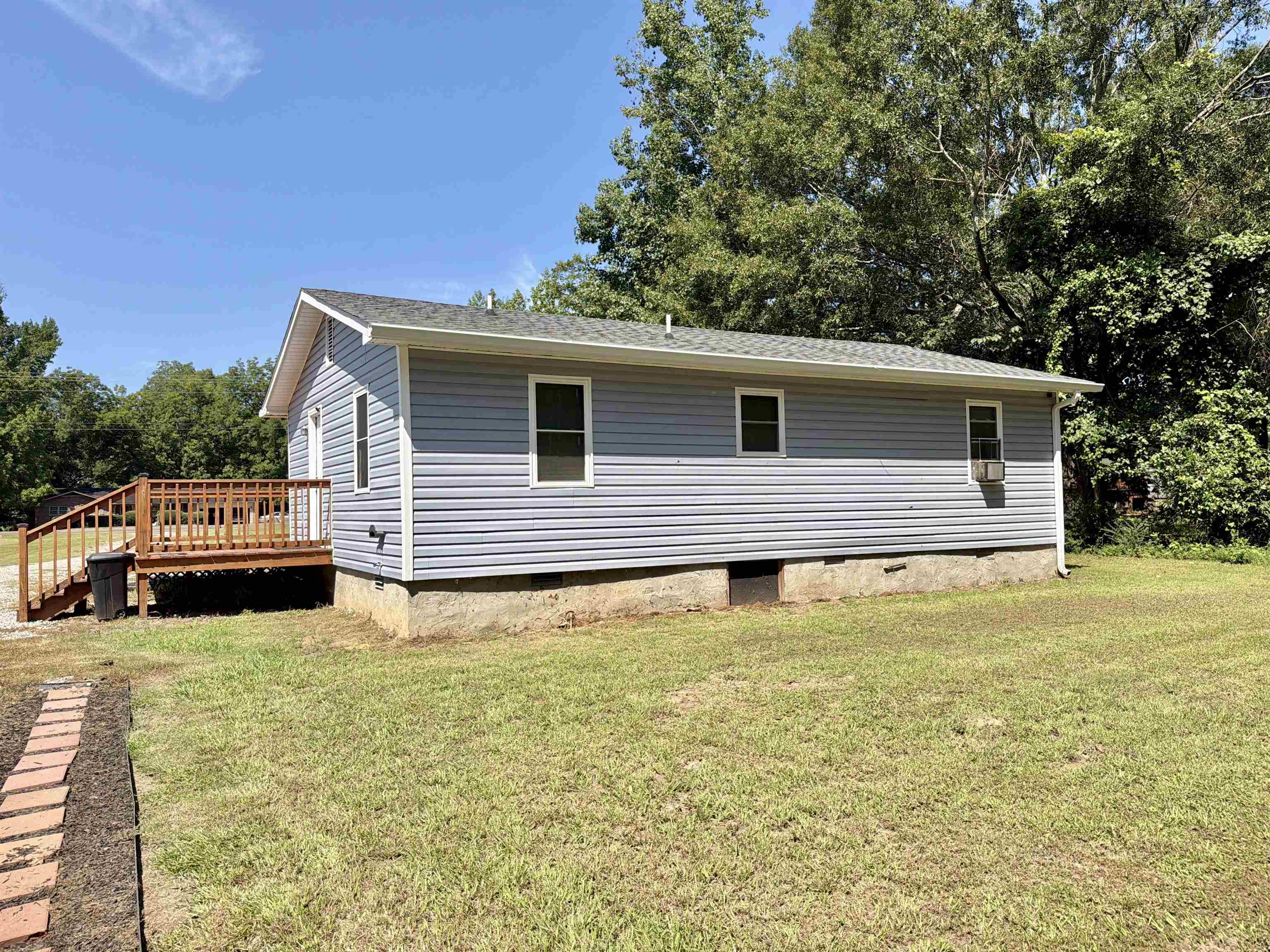 8022 45th Highway Ramer, TN 38367 - Photo 13 of 21 Light blue siding with white trim, brown deck, and a green shingle roof