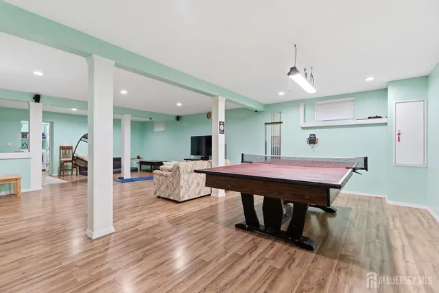 a room with stainless steel appliances wooden floor dining table and chairs