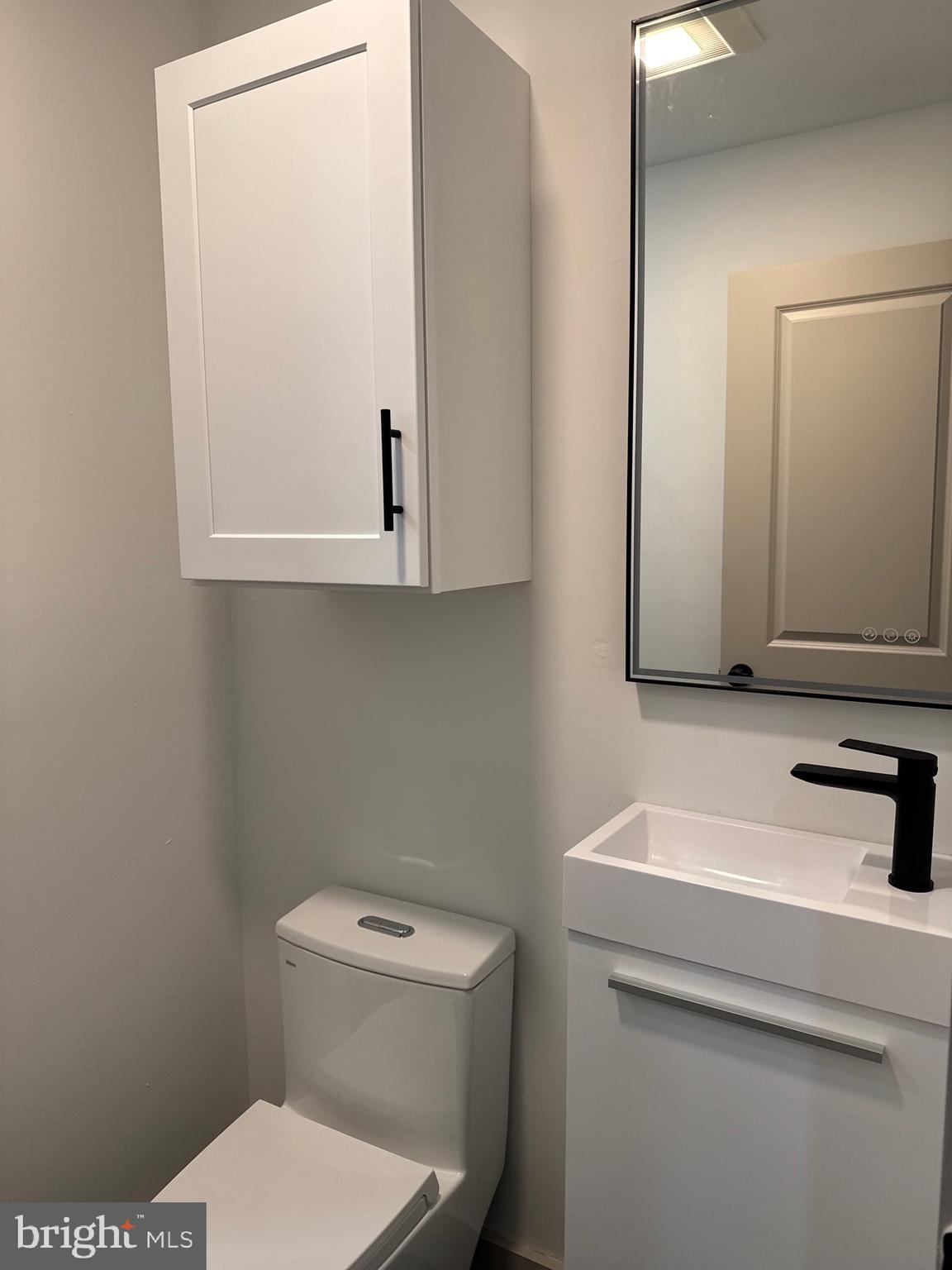 2031 North 19th Street, Unit A Philadelphia, PA 19121 - Photo 12 of 17 a bathroom with a toilet sink and mirror