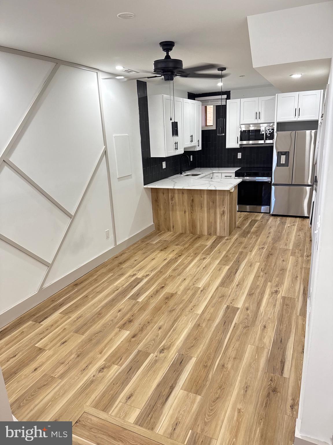 2031 North 19th Street, Unit A Philadelphia, PA 19121 - Photo 2 of 17 a view of a kitchen with stainless steel appliances wooden floor and living room view