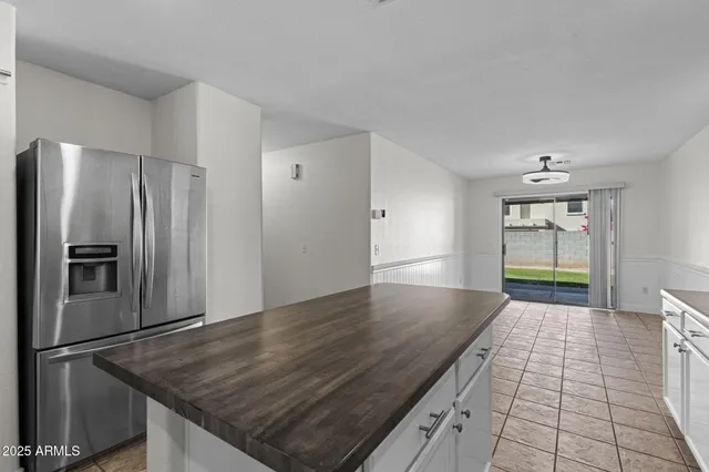 a kitchen with granite countertop a refrigerator and a stove top oven
