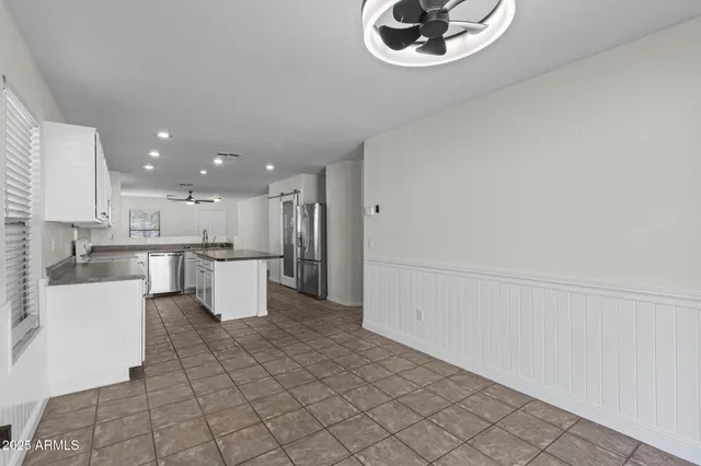 a open kitchen with white cabinets and stainless steel appliances