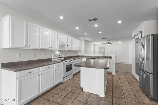 a kitchen with stainless steel appliances granite countertop a refrigerator and a stove top oven