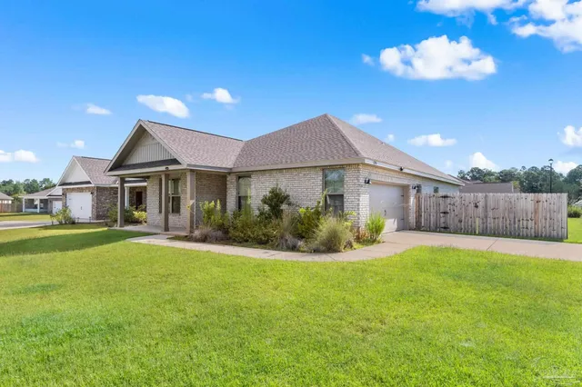 a front view of a house with a garden and yard