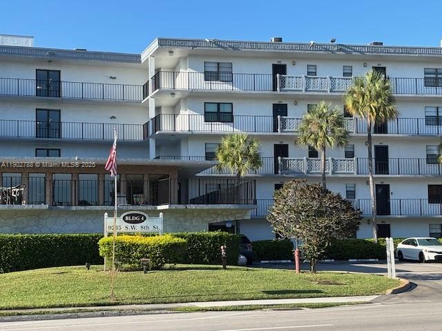 9235 Southwest 8th Street, Unit 510 Boca Raton, FL 33428 - Photo 2 of 23 a front view of a building with garage and plants