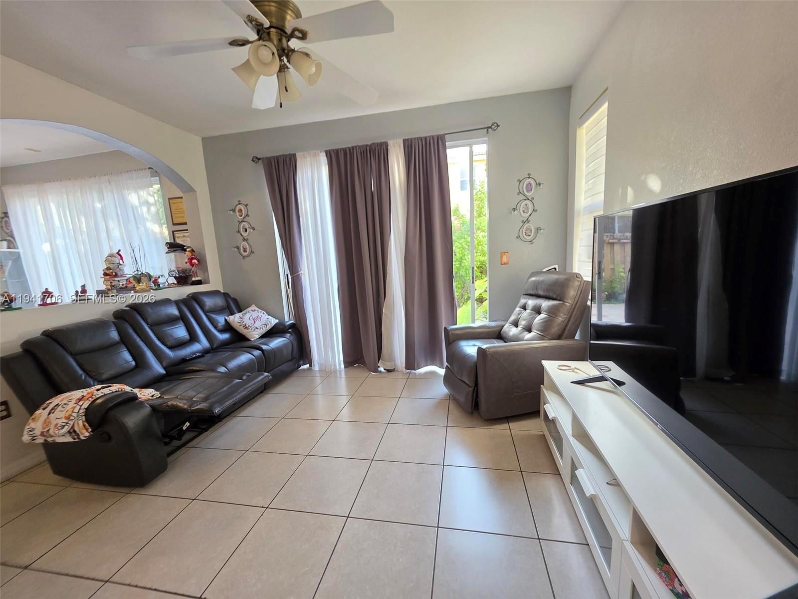 11702 Southwest 137th Place Miami, FL 33186 - Photo 13 of 30 a living room with furniture and a flat screen tv
