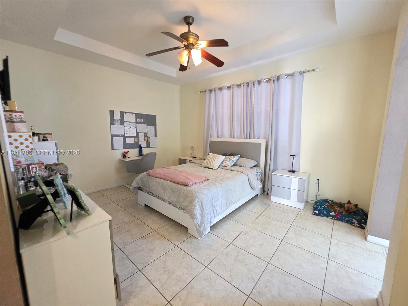 11702 Southwest 137th Place Miami, FL 33186 - Photo 17 of 30 a bedroom with a bed and a chandelier