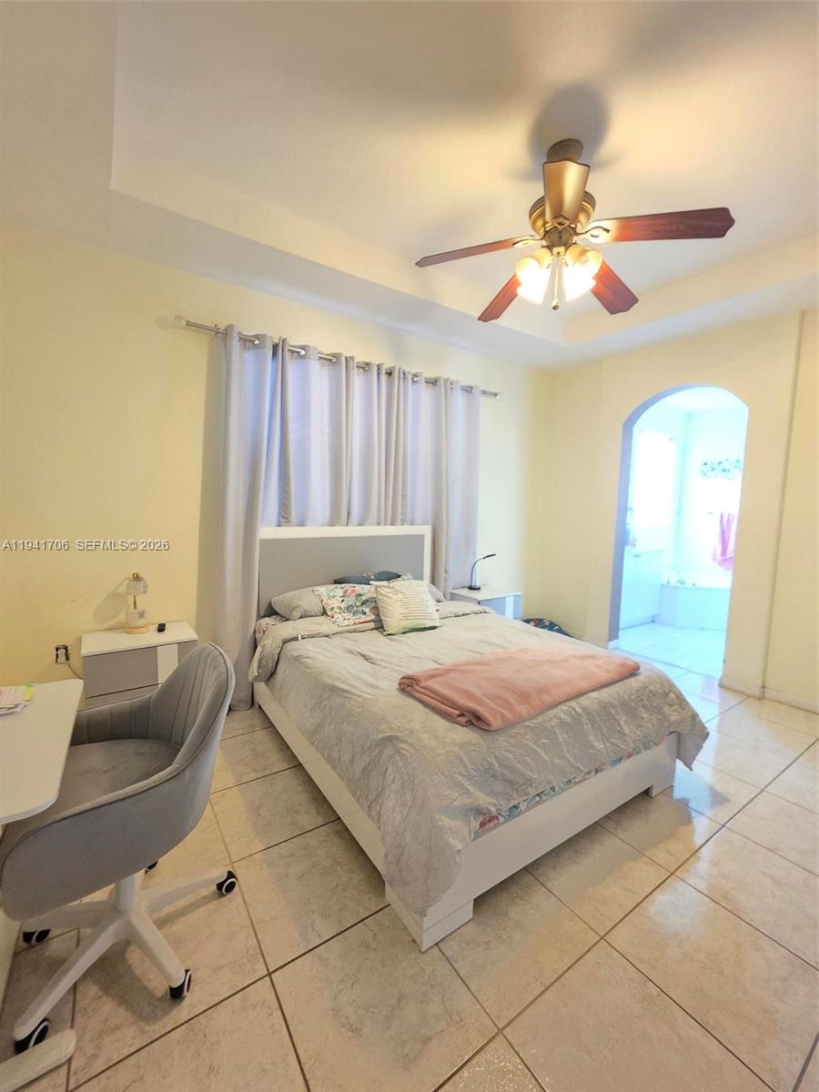 11702 Southwest 137th Place Miami, FL 33186 - Photo 23 of 30 a bedroom with a bed and a chandelier