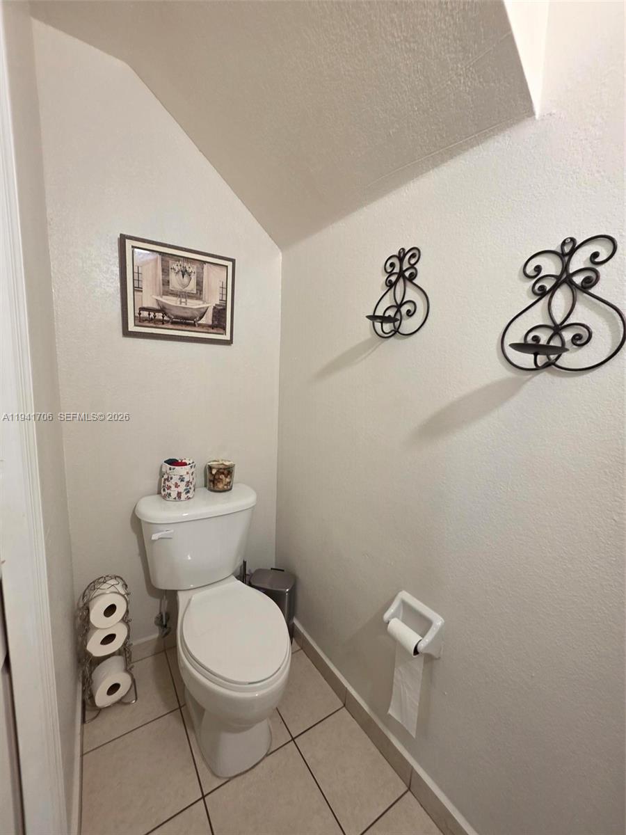 11702 Southwest 137th Place Miami, FL 33186 - Photo 24 of 30 a bathroom with a toilet a sink and mirror