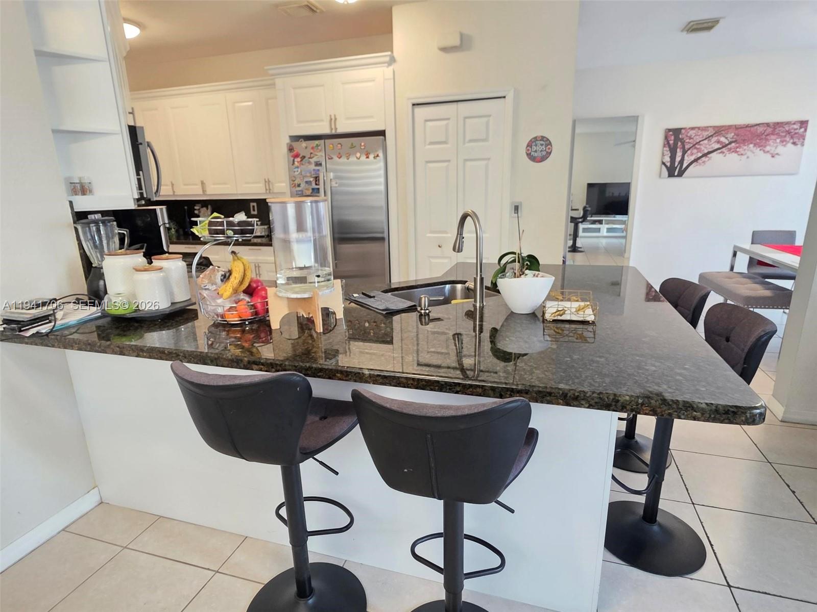 11702 Southwest 137th Place Miami, FL 33186 - Photo 6 of 30 a kitchen with granite countertop a sink cabinets and window