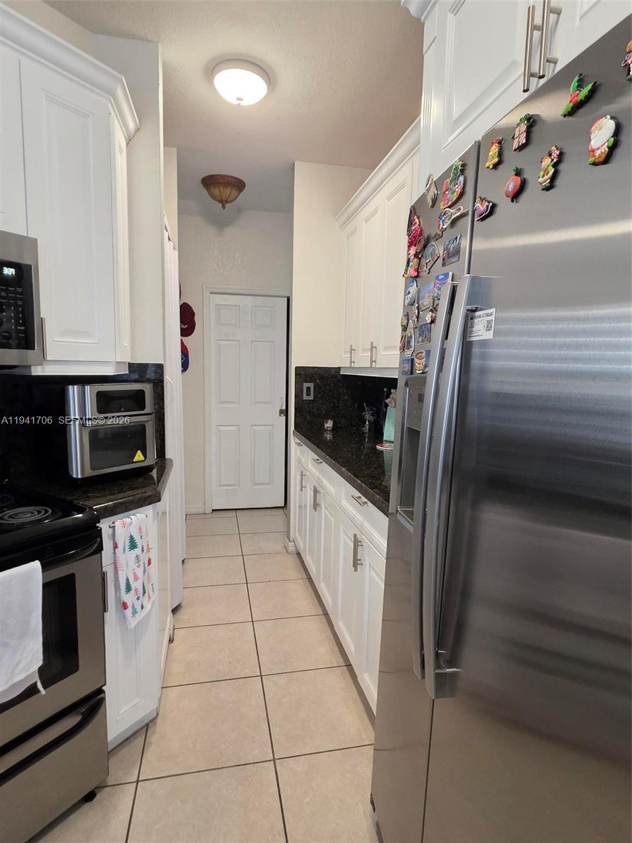 11702 Southwest 137th Place Miami, FL 33186 - Photo 9 of 30 a kitchen with granite countertop a refrigerator and a sink