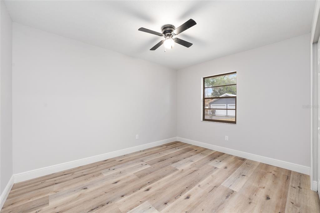 320 Southeast 41st Avenue Ocala, FL 34471 - Photo 25 of 45 an empty room with wooden floor ceiling fan and windows