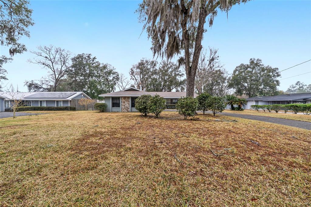 320 Southeast 41st Avenue Ocala, FL 34471 - Photo 44 of 45 a front view of a house with a yard and palm trees