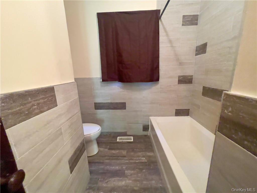 4 Old Turnpike Road Bloomingburg, NY 12721 - Photo 18 of 27 Bathroom with tile walls, wood-type flooring, and toilet