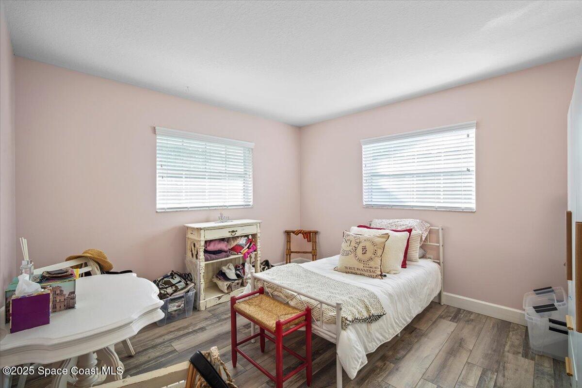 1158 Samar Road Cocoa Beach, FL 32931 - Photo 21 of 29 a bedroom with a bed and wooden floor