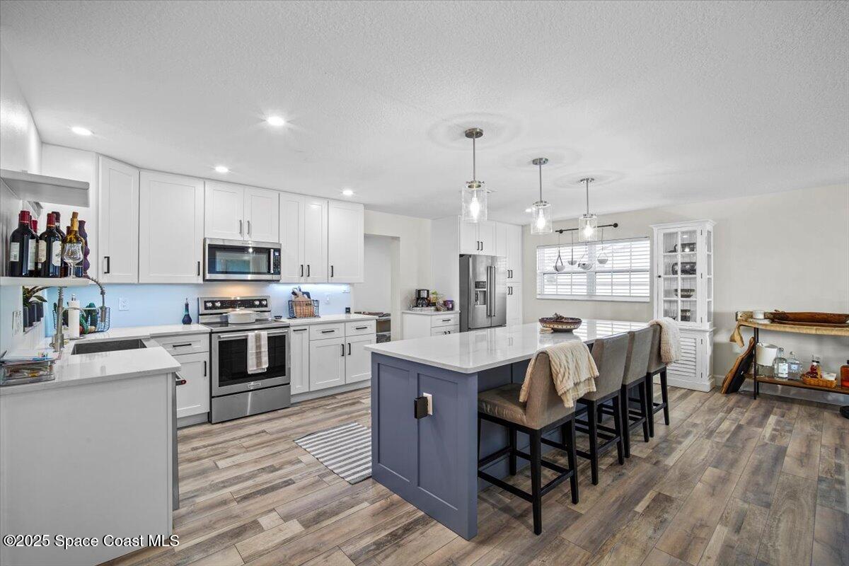 1158 Samar Road Cocoa Beach, FL 32931 - Photo 7 of 29 a kitchen with a table chairs microwave and cabinets