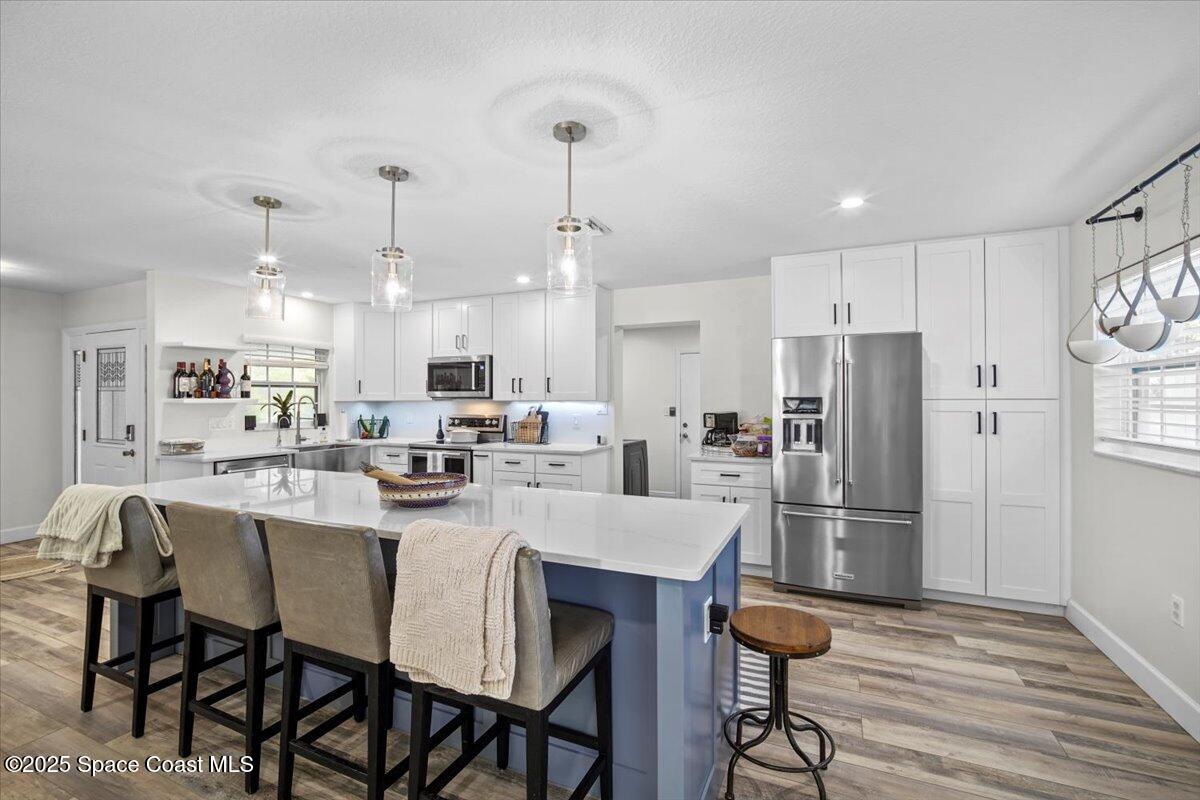 1158 Samar Road Cocoa Beach, FL 32931 - Photo 8 of 29 a kitchen with refrigerator and chairs