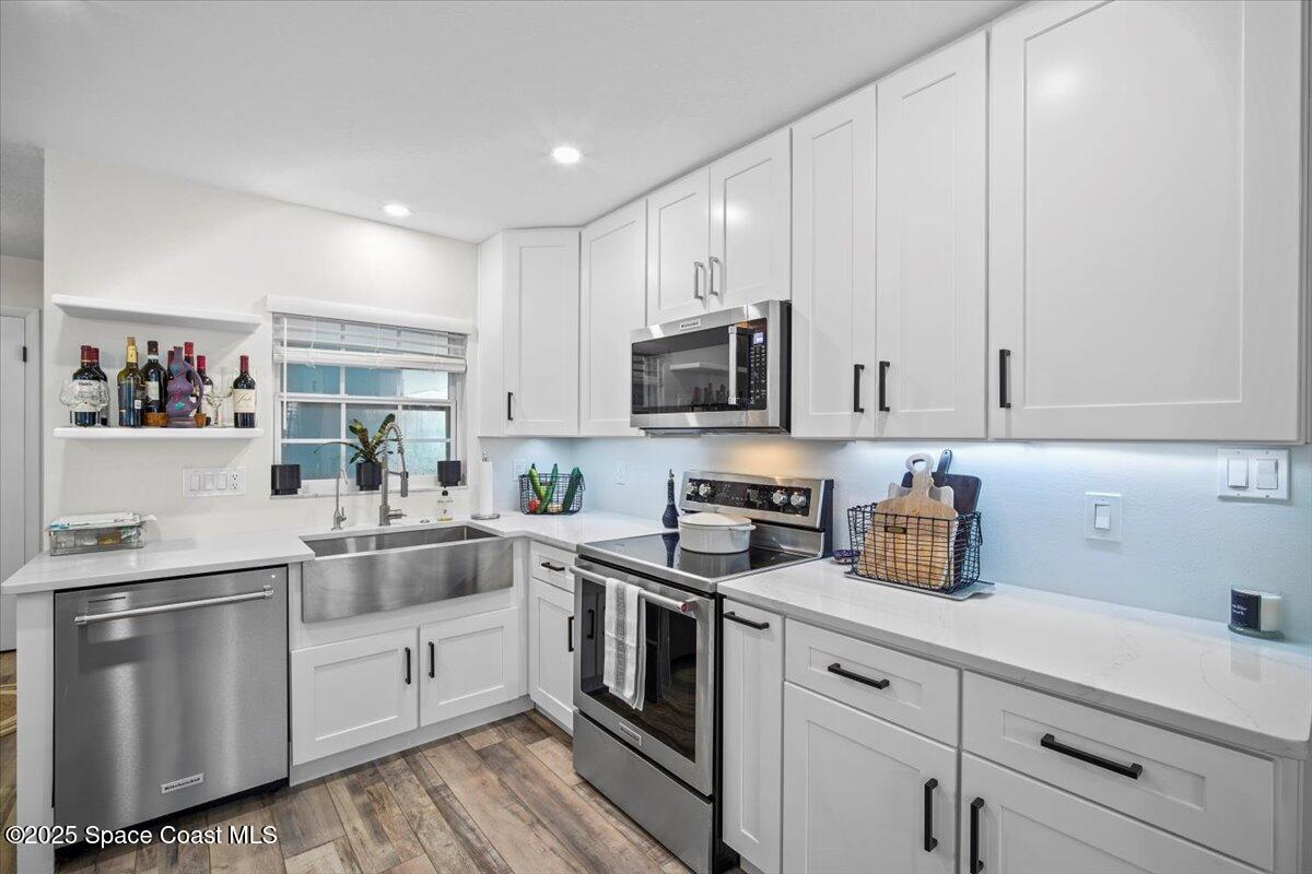 1158 Samar Road Cocoa Beach, FL 32931 - Photo 9 of 29 a kitchen with white cabinets stainless steel appliances and sink