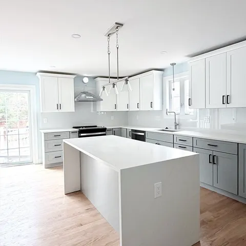 a kitchen with white cabinets sink and stainless steel appliances