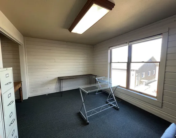 a view of a workspace with furniture and a window