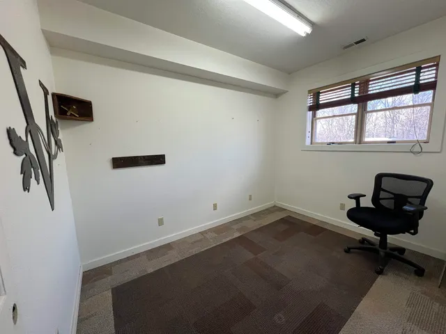 a view of a workspace with furniture and a window